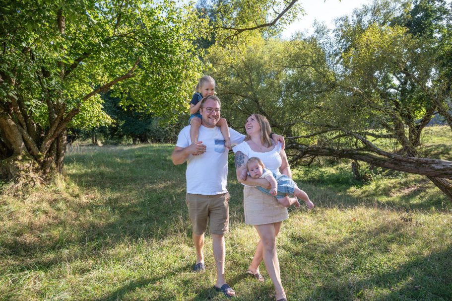 Familienausflug in der Natur mit zwei Kindern und Eltern zwischen Bäumen.